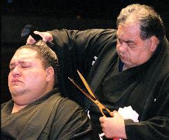 Stablemaster Azumazeki removes the topknot of yokozuna Akebono